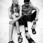 Two models in modern sandals, showcasing minimalist fashion style.