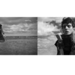 Model in dramatic black attire on a beach under cloudy skies.