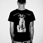 Model wearing a black T-shirt with a horse graphic and tattoos.