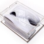 Stylish white Nike sneakers in a clear display box.