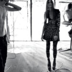 Three models posed in a minimalist, abstract black-and-white setting.