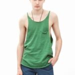 Young man in green tank top and blue shorts.