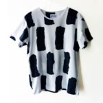 Stylish white t-shirt with bold black abstract patterns.