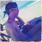 Young man in sunglasses relaxing on a beach.
