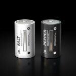 Salt and pepper shakers resembling battery designs on black background.