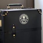 Stylish black trunk luggage with Mastermind World logo.