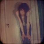 Blurred portrait of a person in a dim hallway.