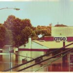 CITGO gas station submerged in floodwaters, surrounded by trees.